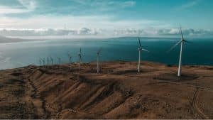 Imagen de un grupo de aerogeneradores instalados sobre una colina, que muestra el impacto de la energía eólica en el paisaje