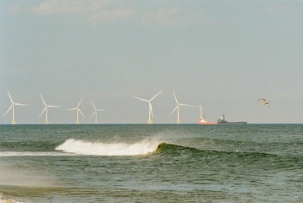 En la imagen se ve un conjunto de molinos de viento en el mar, evidenciando el impacto de la energía eólica marítima en el paisaje