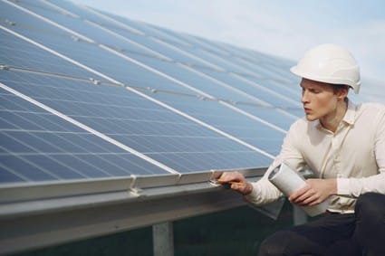 Un trabajador examina un panel solar en una planta fotovoltaica. Esta imagen refleja el creciente interés en aumentar la producción y la rentabilidad de la energía solar en España.